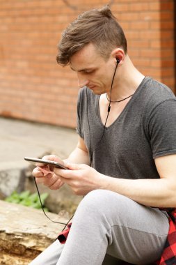 kulaklıklarla rahat kıyafetler içinde genç adam 