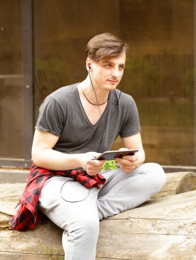 kulaklıklarla rahat kıyafetler içinde genç adam  