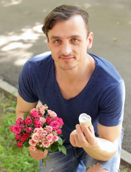 man with  bouquet of roses and diamond ring, ready to make a proposal