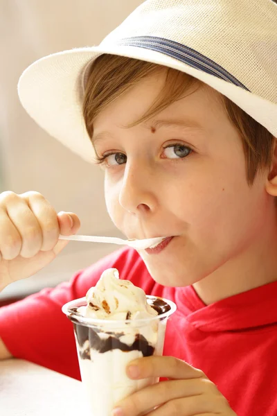 Jongen eten ijs met chocolade siroop — Stockfoto
