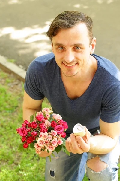 man with  bouquet of roses and diamond ring, ready to make a proposal