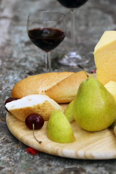 Cheeseboard with pears and wine on a table in the garden — Stock Photo, Image