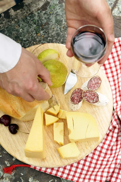 Cheeseboard with pears and wine on a table in the garden — Stock Photo, Image