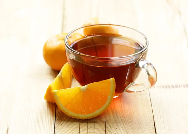 Glas kopp med te och citrusfrukter på bordet — Stockfoto