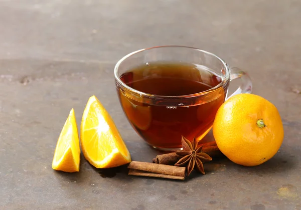 Glas kopp te med anis, kanel och citrus frukter på bordet — Stockfoto