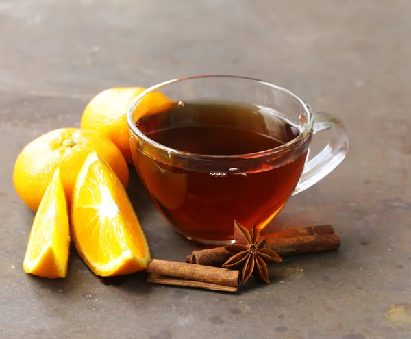 Glazen kopje thee met anijs, kaneel en citrus vruchten op tafel — Stockfoto