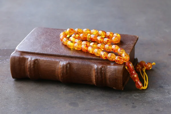 Livre dans une reliure en cuir vintage, et perles ambre — Photo