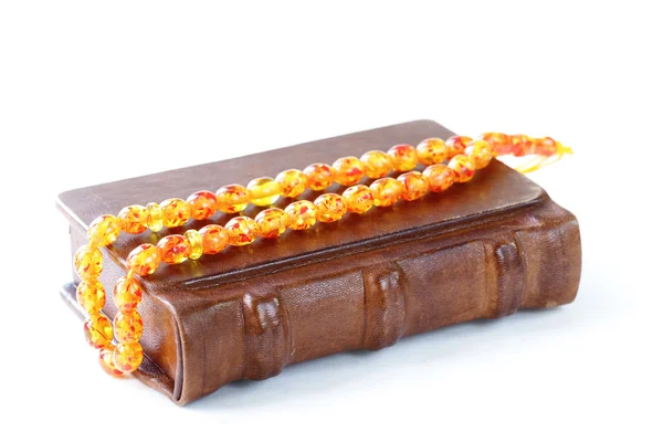 Livre dans une reliure en cuir vintage, et perles ambre — Photo