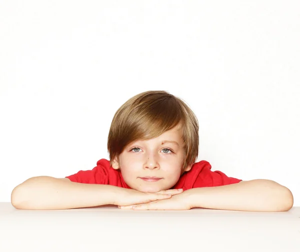 Mignon garçon blond dans la chemise rouge sur un fond blanc — Photo