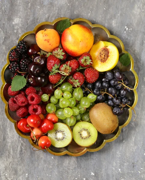 Various fresh organic berries on a vintage silver plate — Stock Photo, Image