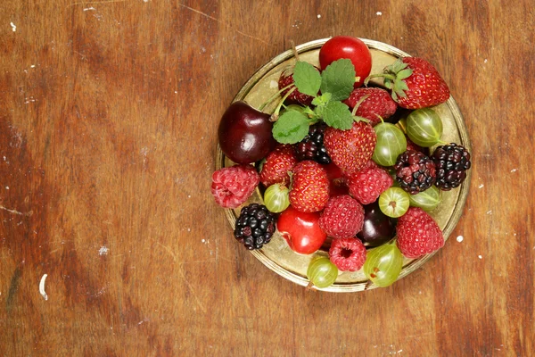 Various fresh organic berries on a vintage silver plate — Stock Photo, Image