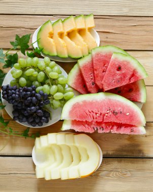 olgun organik meyve karpuz, karpuz kavun ve üzüm ahşap bir masa, üstten görünüm