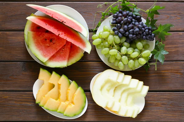 olgun organik meyve karpuz, karpuz kavun ve üzüm ahşap bir masa, üstten görünüm