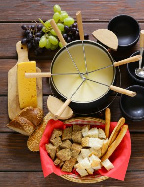 Geleneksel mutfak eşyaları fondü, ekmek, peynir ve üzüm için kümesi