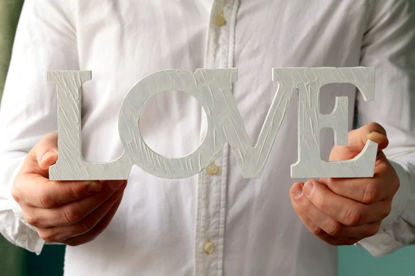 Muž v bílé košili drží slovo "láska" — Stock fotografie