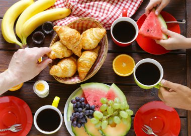 kahve, kruvasan ve meyve kahvaltı ahşap bir tabloda, üstten görünüm