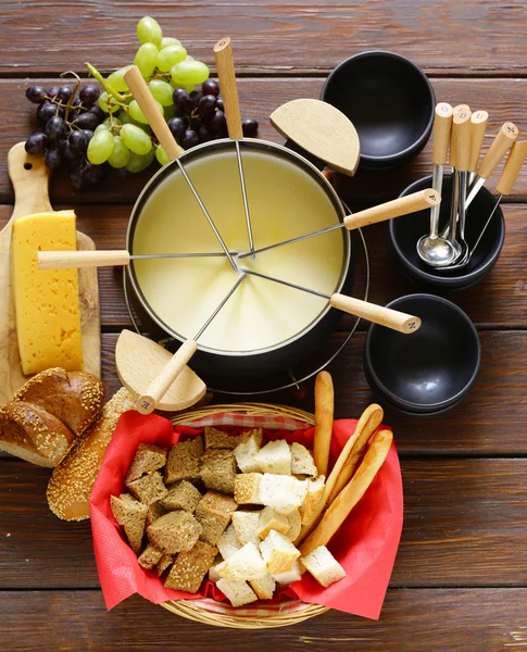 Set de utensilios tradicionales para fondue, con pan, queso y uvas — Foto de Stock