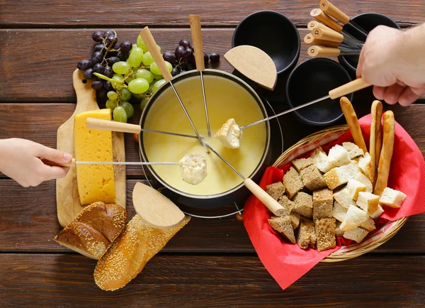 Conjunto tradicional de utensílios para fondue, com pão, queijo e uvas — Fotografia de Stock