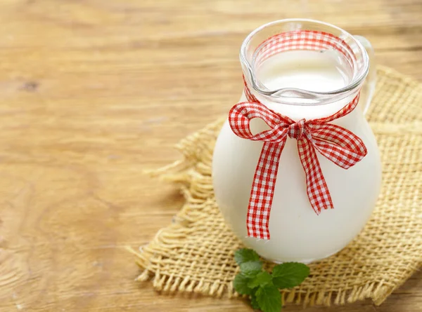 Ahşap bir masa üzerinde bir cam kavanoza doğal organik süt — Stok fotoğraf