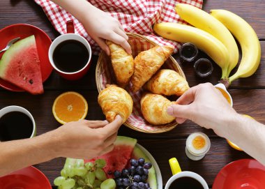 kahve, kruvasan ve meyve kahvaltı ahşap bir tabloda, üstten görünüm