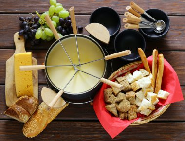 Geleneksel mutfak eşyaları fondü, ekmek, peynir ve üzüm için kümesi