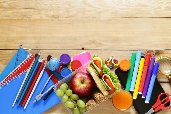 Papelaria escolar e lancheira com maçã, uvas e sanduíche — Fotografia de Stock