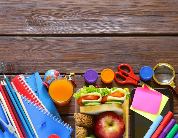 School stationery and lunch box with apple, grapes and sandwich — Stock Photo, Image