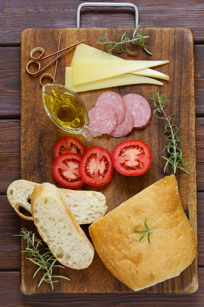 Tradicional italiano ciabatta pão com queijo, salsicha, tomate e azeite — Fotografia de Stock