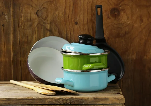 Set of metal pots cookware on a wooden, domestic kitchen — Stock Photo, Image