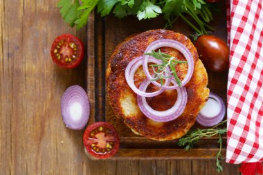 Kızarmış pirzola otlar ve ahşap bir gemide soğan ile