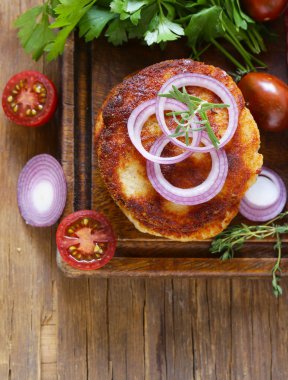 Kızarmış pirzola otlar ve ahşap bir gemide soğan ile