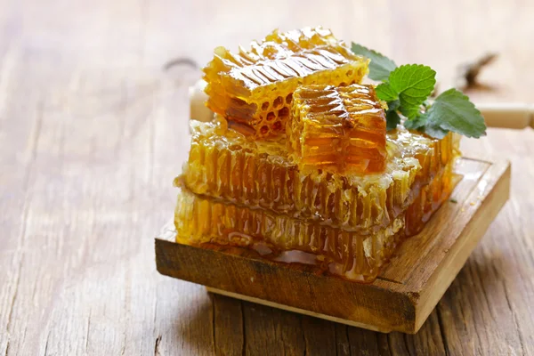 天然有机蜂蜜，蜂窝木制的桌子上 — 图库照片