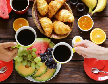 kahve, kruvasan ve meyve kahvaltı ahşap bir tabloda, üstten görünüm