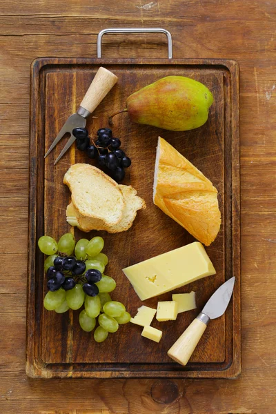 Tabla de quesos con uvas, pera y baguette — Foto de Stock