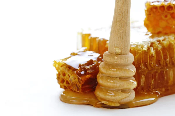 Favo de mel e mergulhador de mel em um fundo branco — Fotografia de Stock