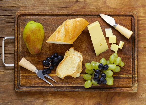 Сырная доска с виноградом, грушей и багетом — стоковое фото