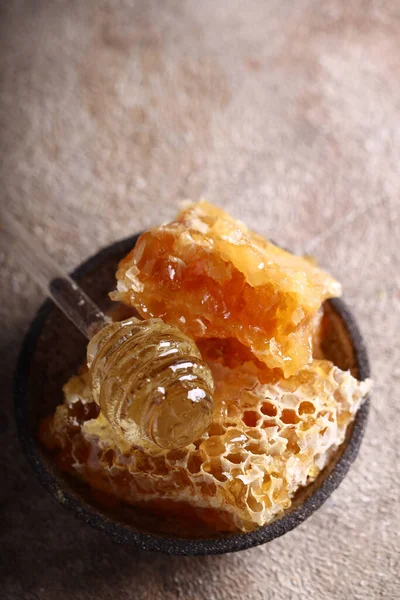 用勺子把天然有机蜂蜜放在梳子里 — 图库照片