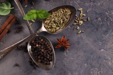 Karanlık bir arka planda kaşıklardaki çeşitli baharatlar