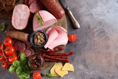 Ahşap arka planda sosis ve jambon çeşitleri, pastırma, aperatif.