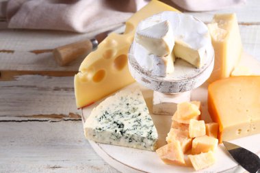 Tahta arka planda peynirli, peynirli ve parmesanlı.