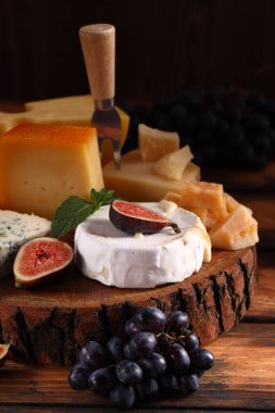 Tahta arka planda peynirli, peynirli ve parmesanlı.