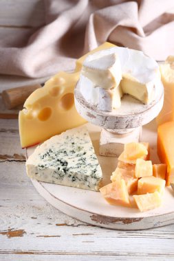 Tahta arka planda peynirli, peynirli ve parmesanlı.