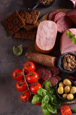 Ahşap arka planda sosis ve jambon çeşitleri, pastırma, aperatif.