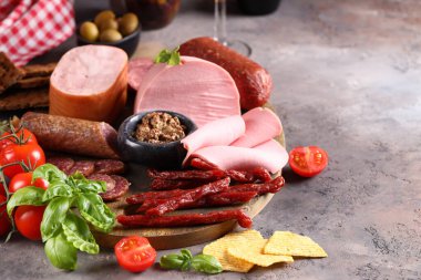 Ahşap arka planda sosis ve jambon çeşitleri, pastırma, aperatif.
