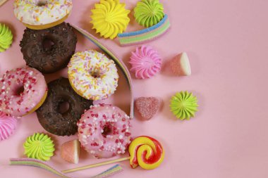 Donut ve şeker reçeli pembe arka planda.