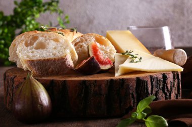 Peynir tabağında ekmek ve masada meyveler.