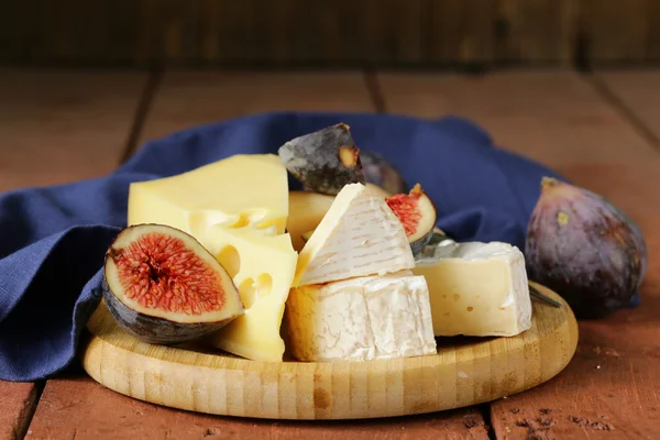 Cheeseboard with maasdam, camembert, cheddar cheese and figs — Stock Photo, Image