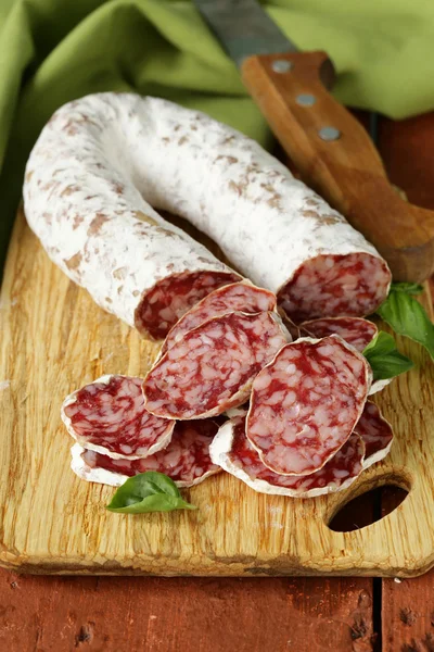 Delicacy smoked sausage (salami) on a wooden board — Stock Photo, Image