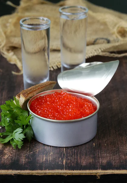 Caviar con pan de centeno y dos chupitos de vodka en una mesa de madera — Foto de Stock