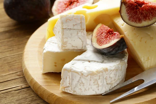 Cheeseboard with maasdam, camembert, cheddar cheese and figs — Stock Photo, Image